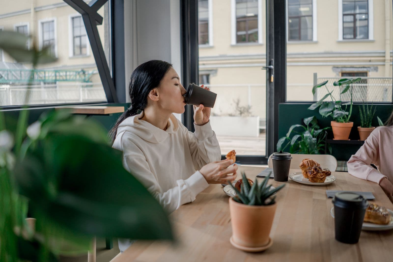 Asian woman enjoying coffee during a relaxed café break